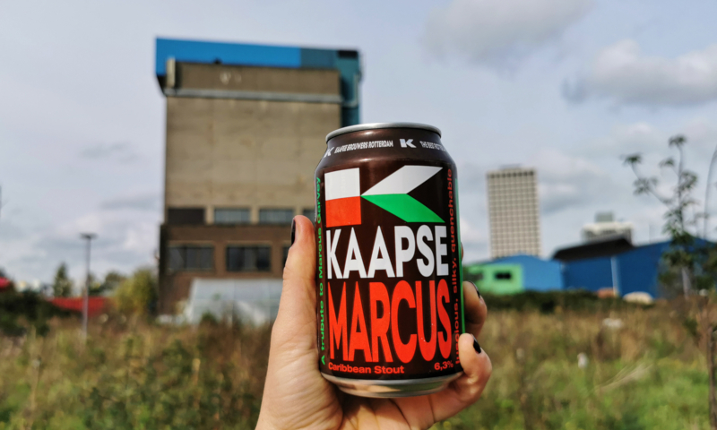 Blikje Kaapse Marcus speciaalbier in de hand gehouden op een industrieterrein